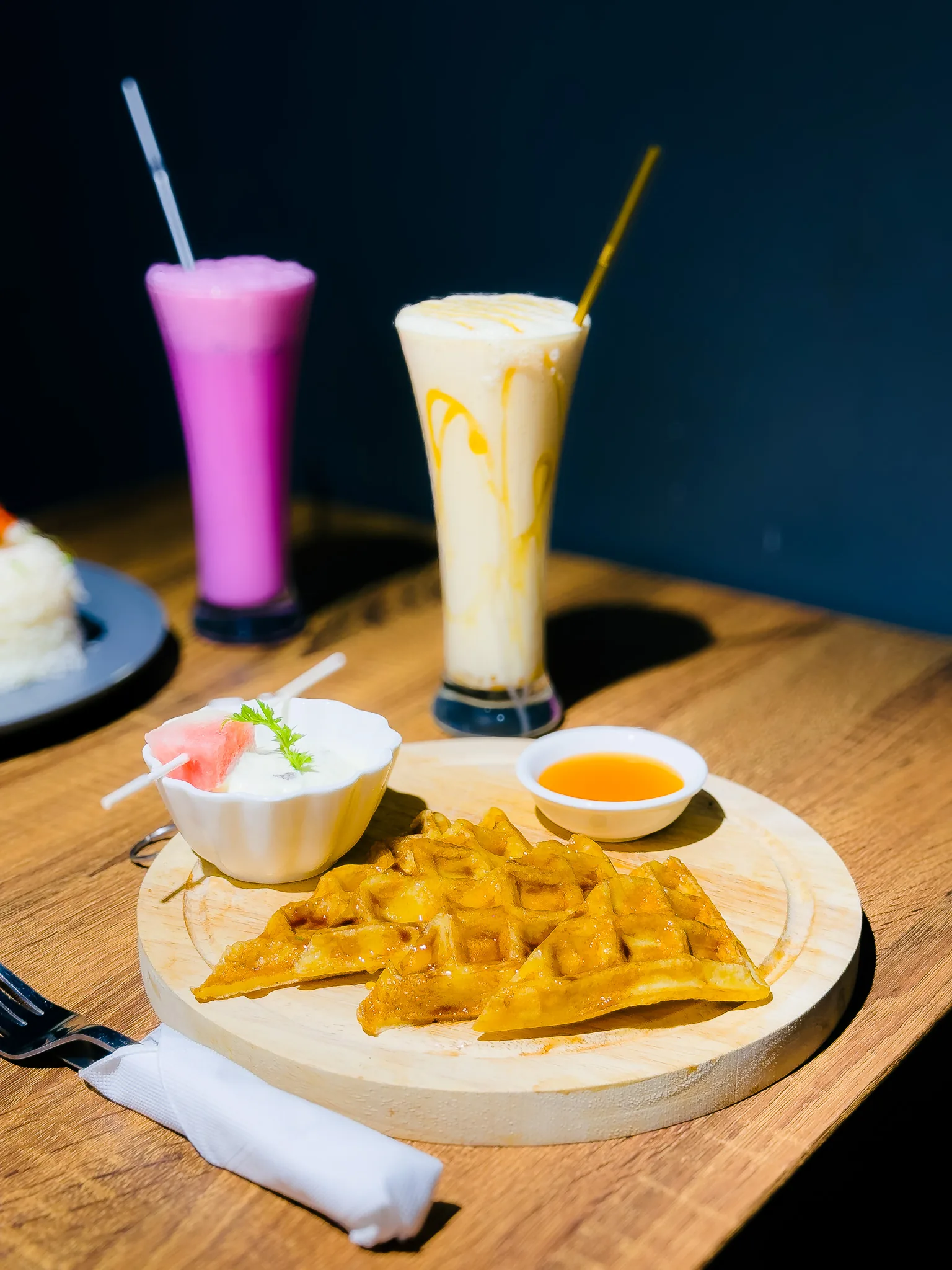 Waffles and colourful drinks on a table