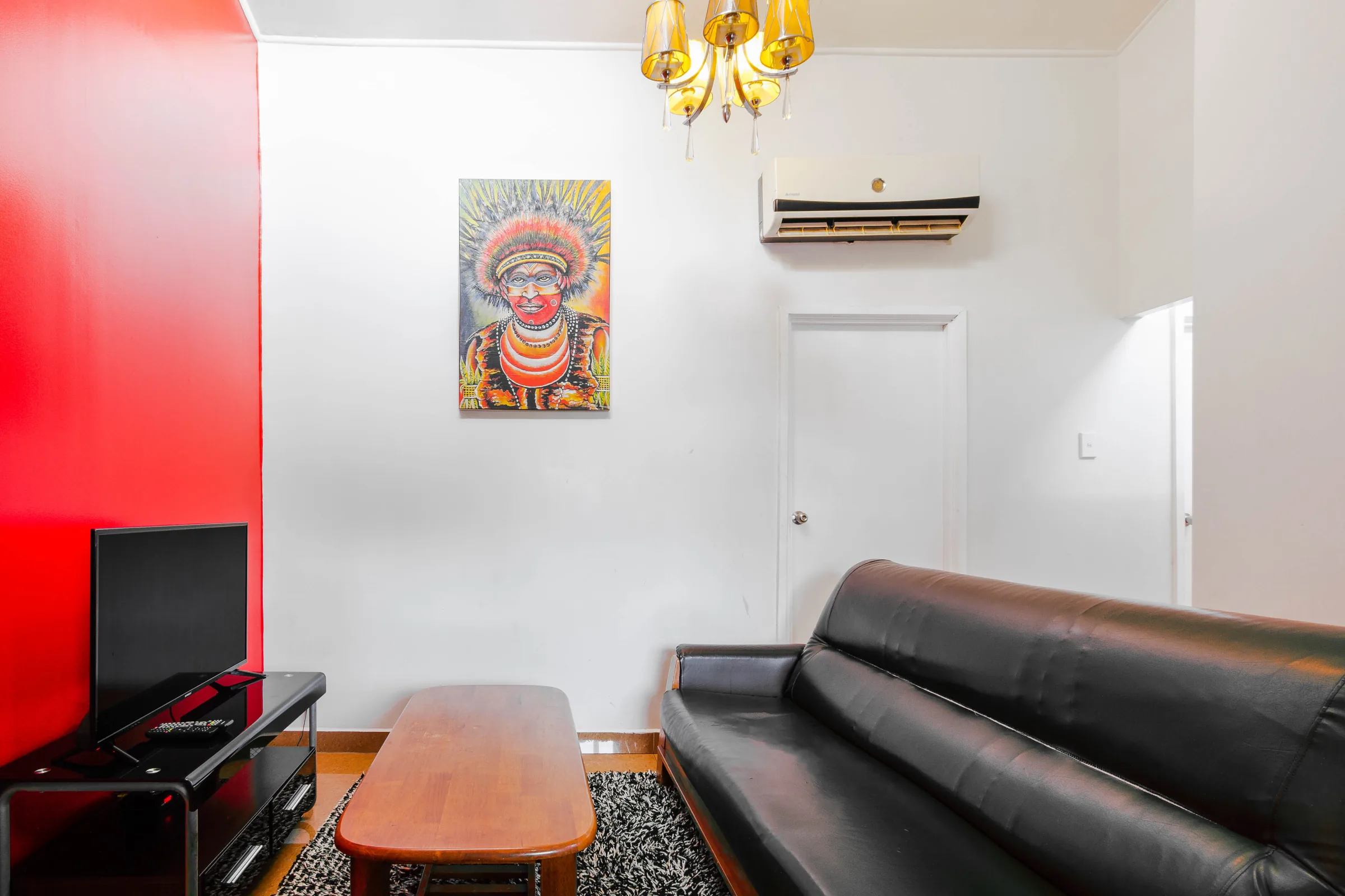 Living room with a red feature wall and dark sofa