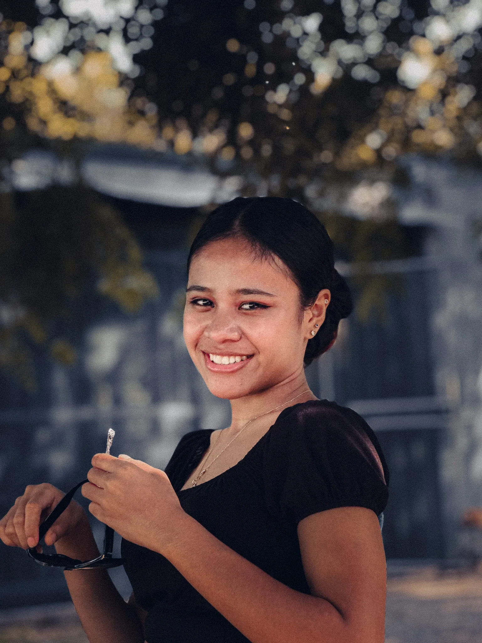 Portrait of a smiling woman holding sunglasses