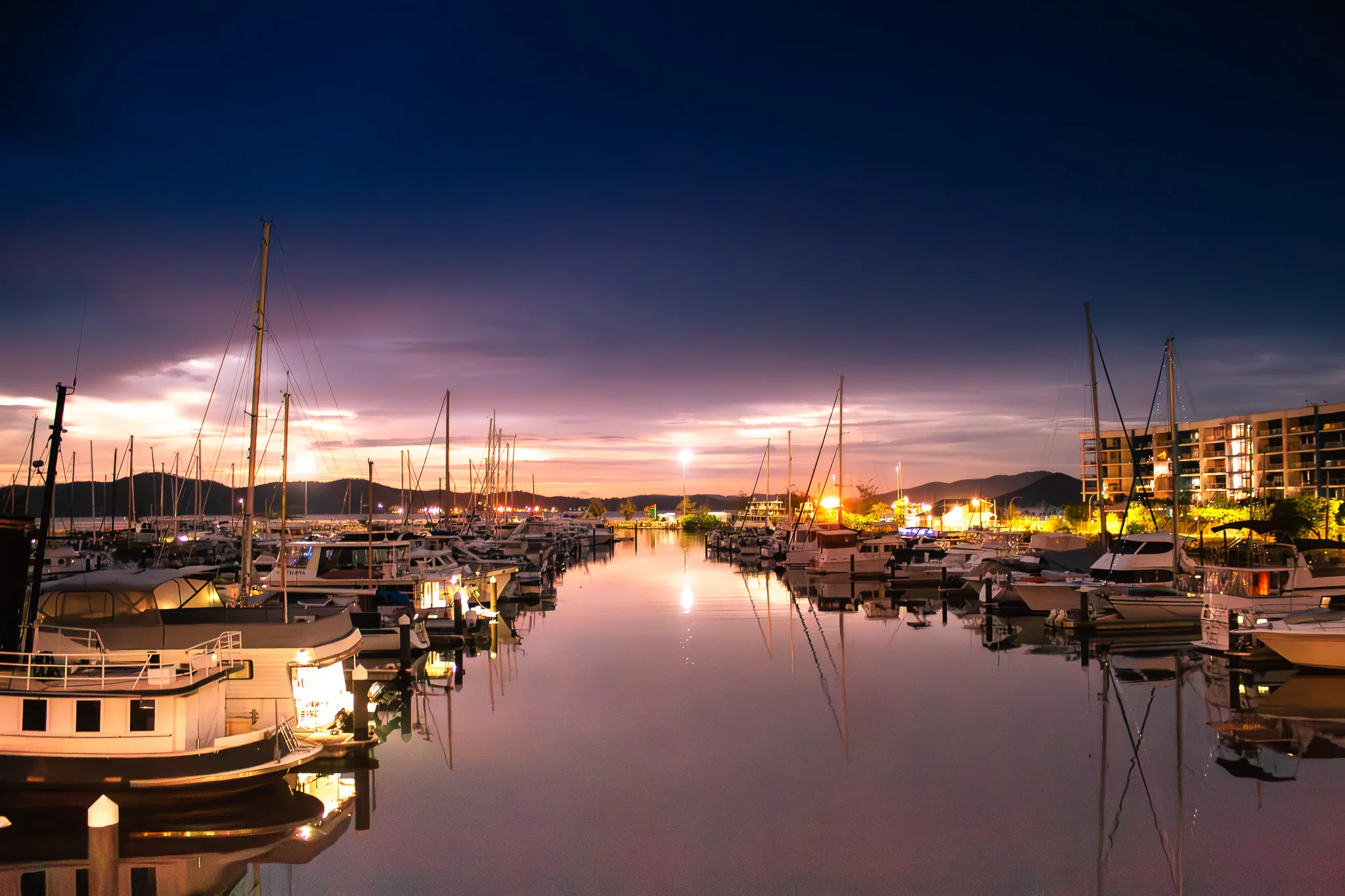 Boats and reflections at a marina at dusk